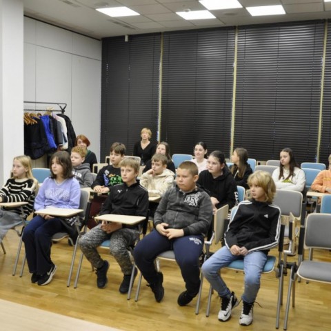 Powiększ obraz: grupa dzieci siedząca na krzesłach w sali konferencyjnej