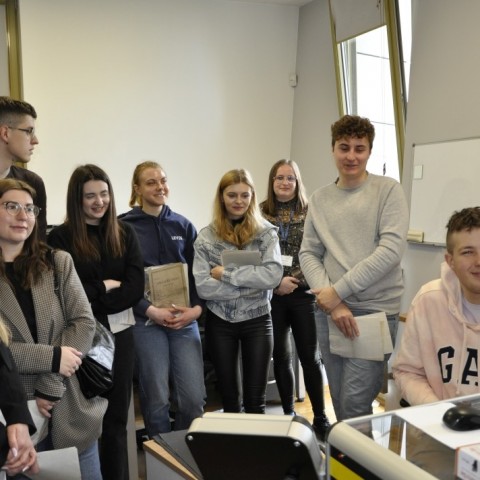 Powiększ obraz: studenci stoją w pracowni digitalizacji