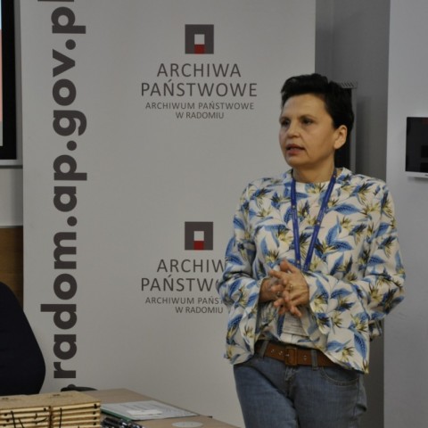 Powiększ obraz: prowadząca spotkanie stoi