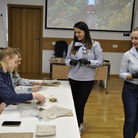 Powiększ obraz: studzenci siedzą przy stołach w sali konferencyjnej, na stołach materiały do konserwacji akt