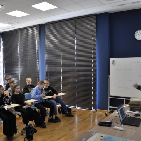 Powiększ obraz: grupa uczniów siedząca przez prowadzącą zającia w sali konferencyjnej